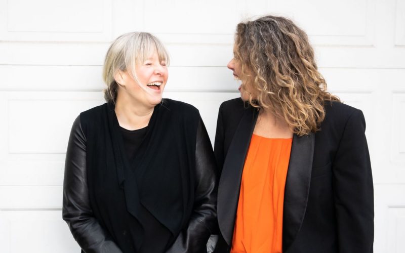 Two women podcasters laughing