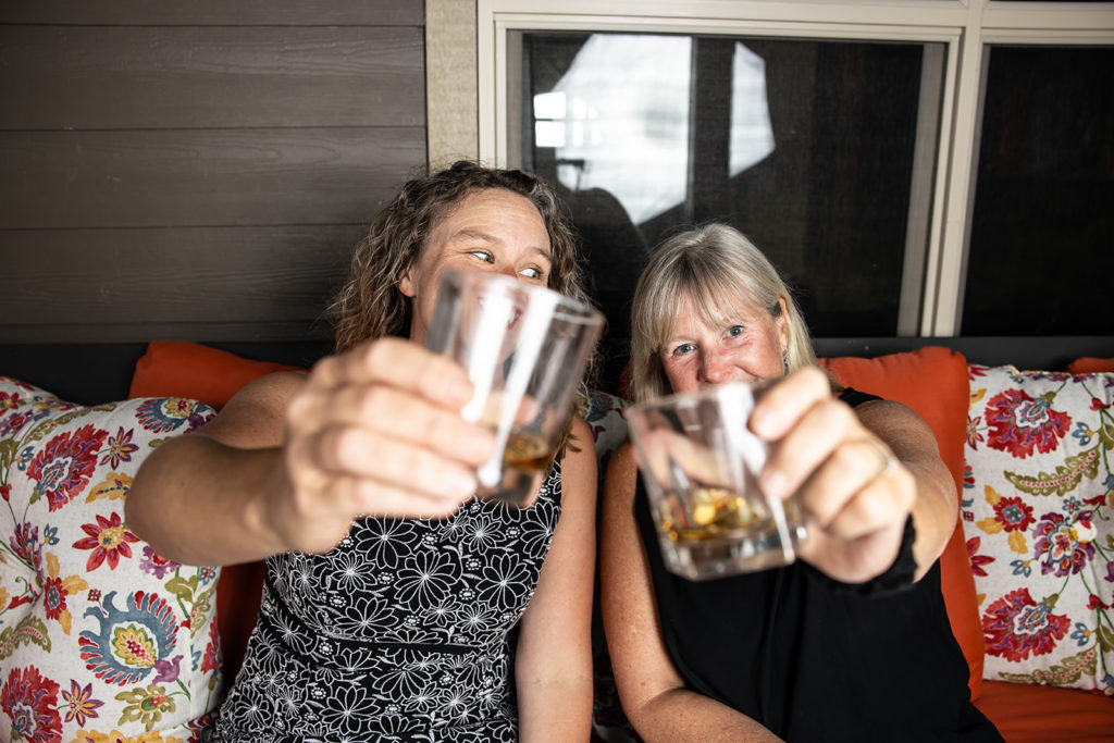 Two women clink glasses and "cheers" to the future of work, which is predicted to be more humane and human-centered